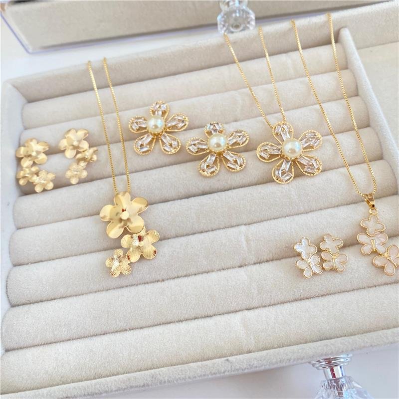  CONJUNTO FLOR COM DETALHES EM BAGUETES E PÉROLA BANHO OURO 18K