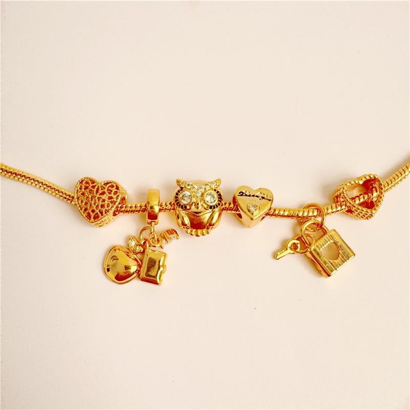 PULSEIRA DREAMS COM BERLOQUES CORAÇÃO CADEADO CORUJA MAÇÃ E MALA BANHO OURO 18K -BREVE REPOSIÇÃO